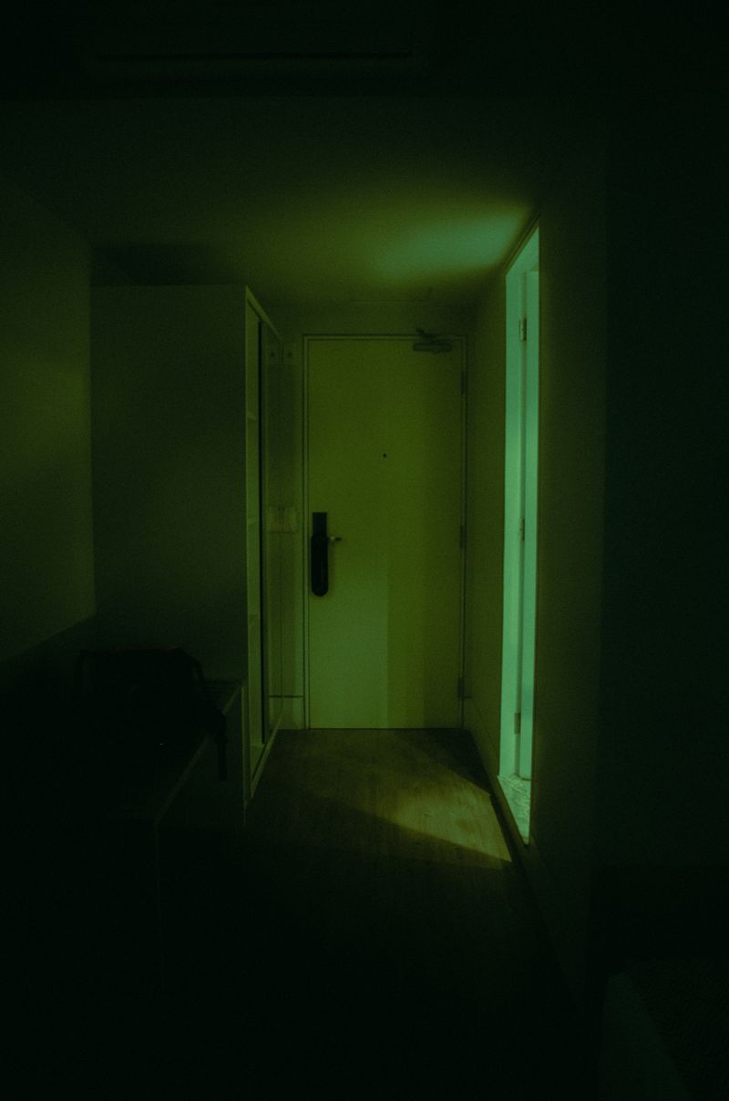 A closed door softly lit in a dim hallway